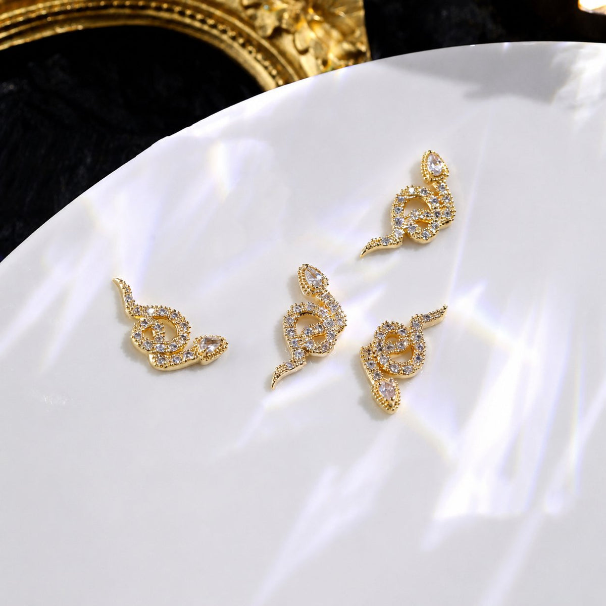 Gold rhinestone snake nail charms with clear stone detailing