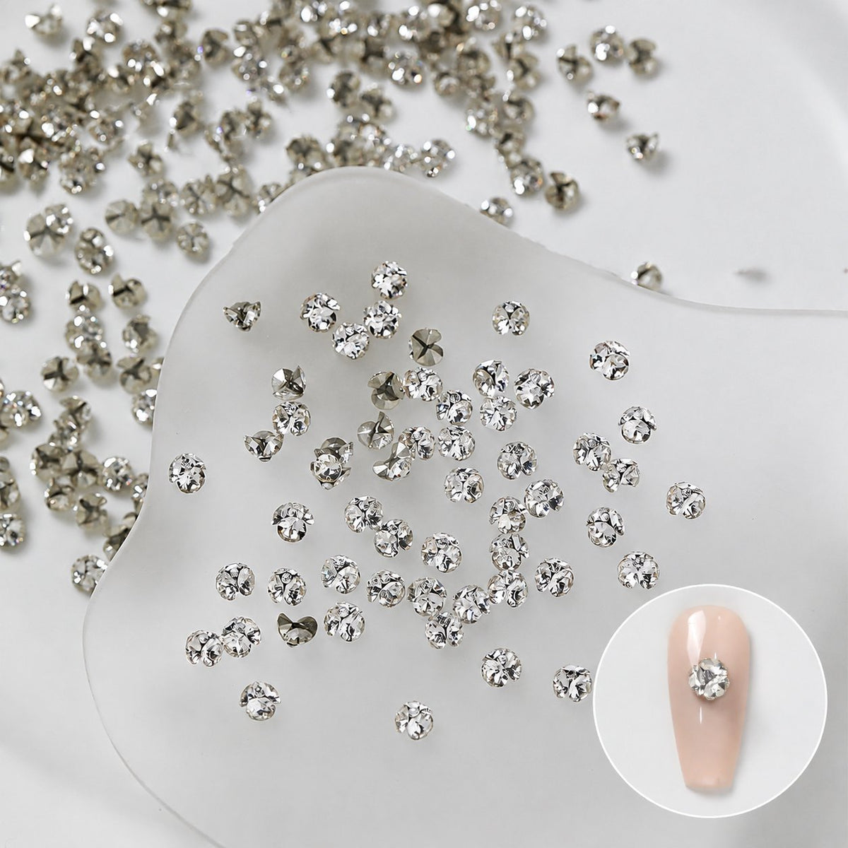 Silver nail rhinestone cluster shown on a nude nail swatch