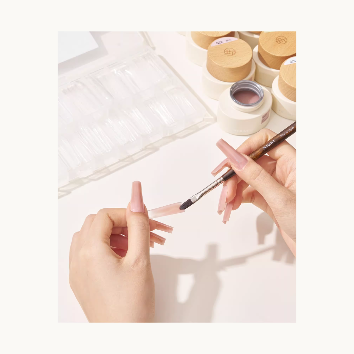 Applying extension gel with a brush to a nail mold