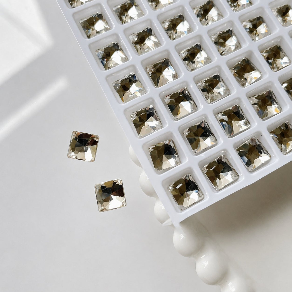 Smoky gold 8 × 8 mm square nail charms in a tray