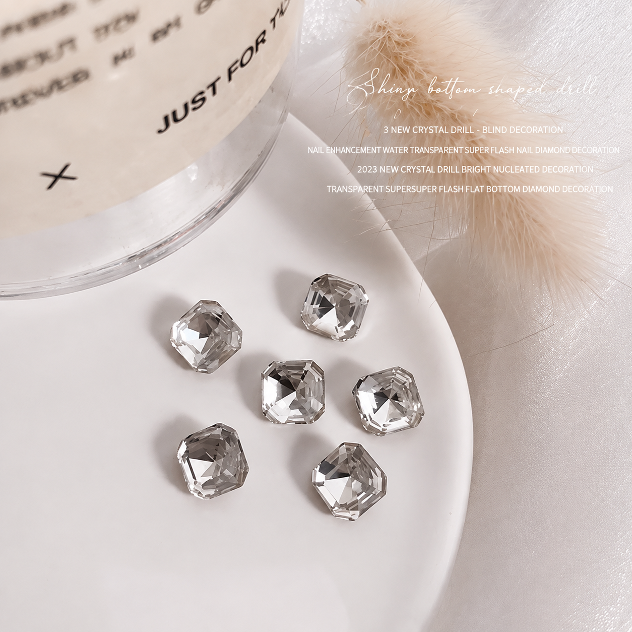 Clear faceted nail charms arranged on a white dish