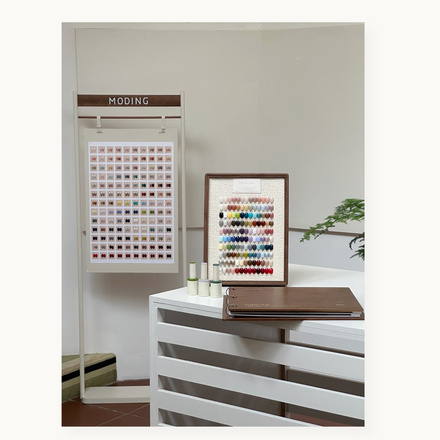 MODING 130-color full set displayed on standing board with bottle gels and color chart book in a studio setting.