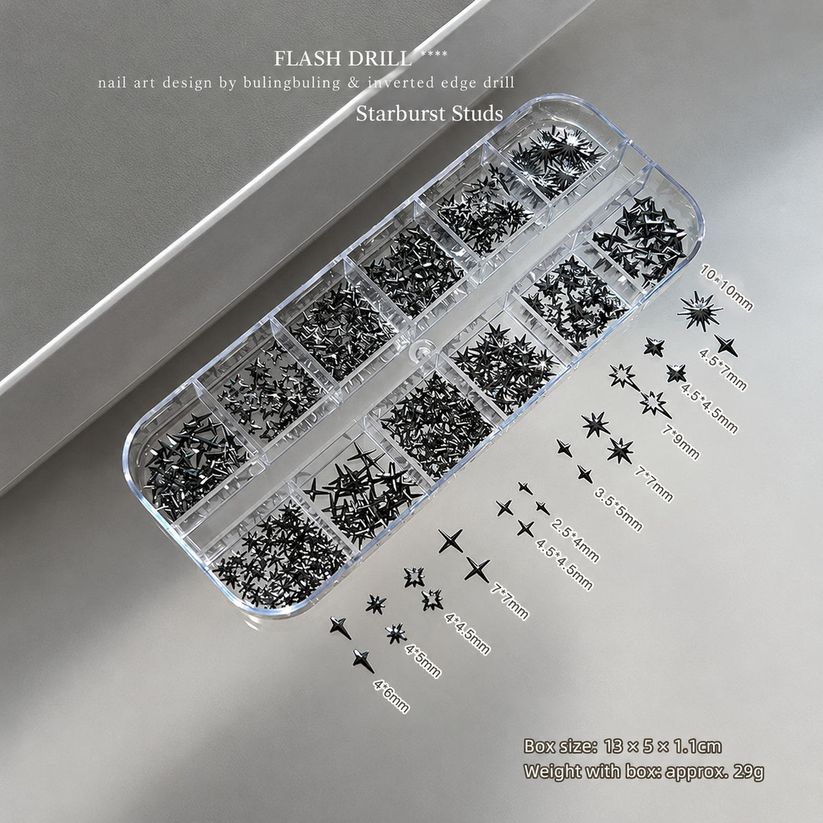 NF x Gunmetal Starbust Studs in a clear 12-grid box, with assorted dark metallic star nail studs and individual size labels.