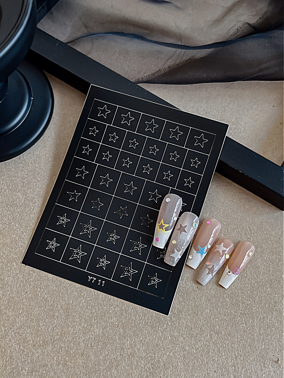 Star nail art sticker sheet with translucent sample nails and rhinestones