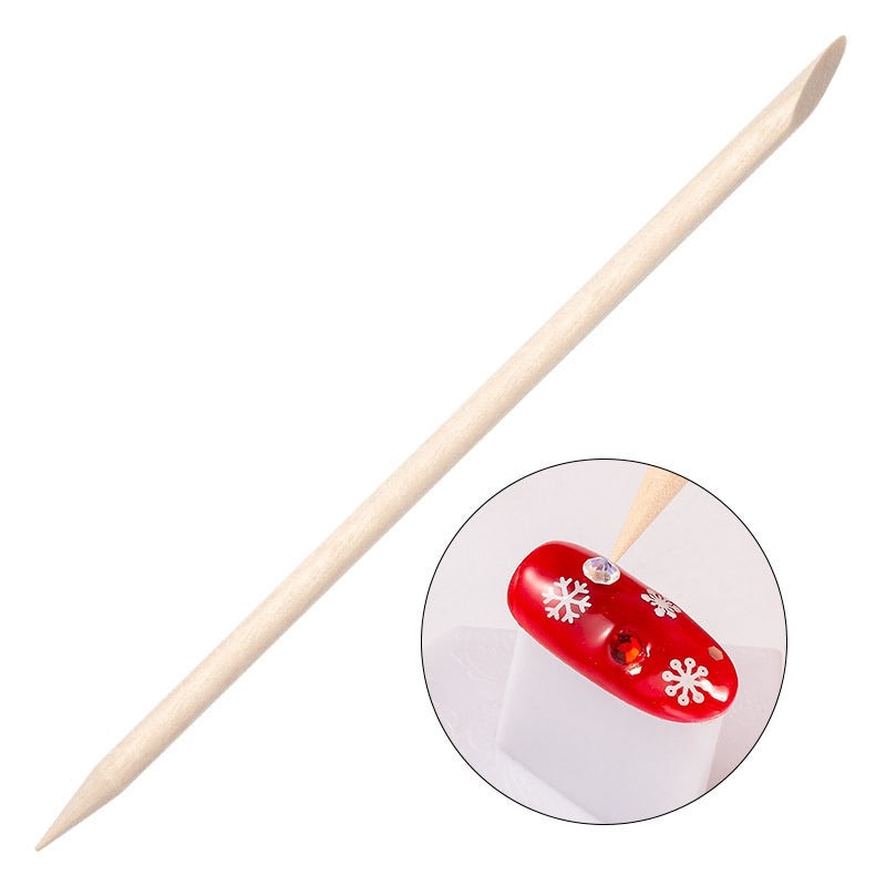 Pointed wooden nail art stick beside a decorated red nail example