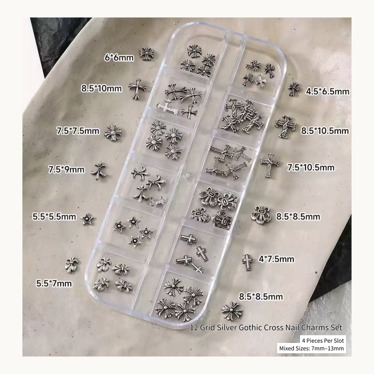 Silver gothic cross nail charms in a 12-grid organizer with loose pieces