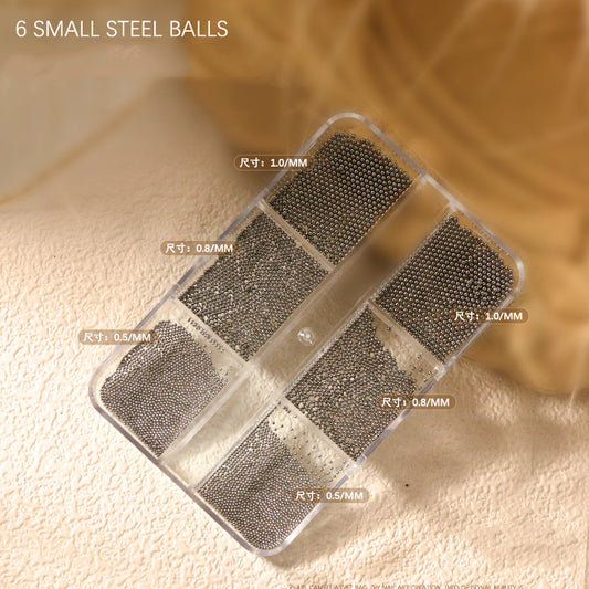 Black steel nail art beads in six compartments labeled 0.5 to 1.0 mm