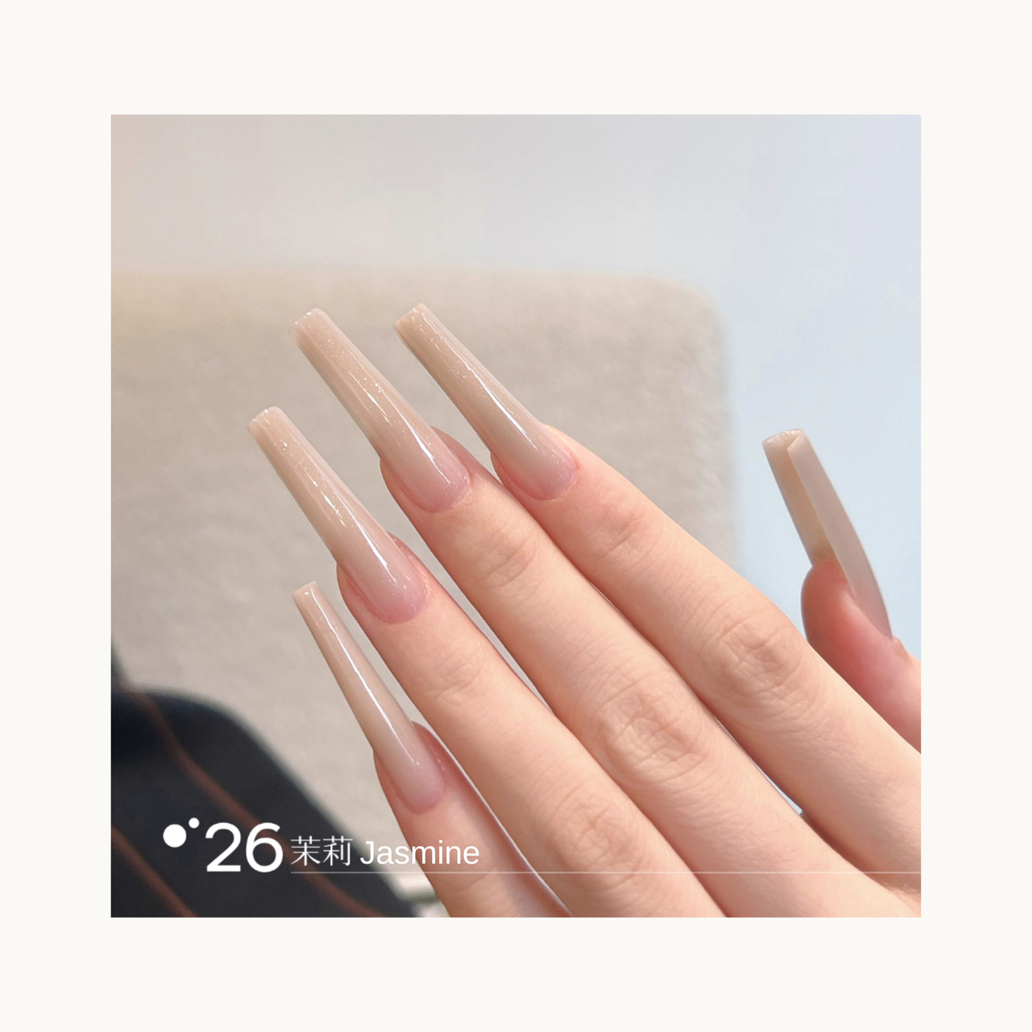Long coffin-shaped nails painted in shade Q26 Jasmine, a soft beige nude gradient with a smooth glossy shine.