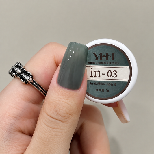 Gray-green nail color gel applied beside the in-03 gel pot