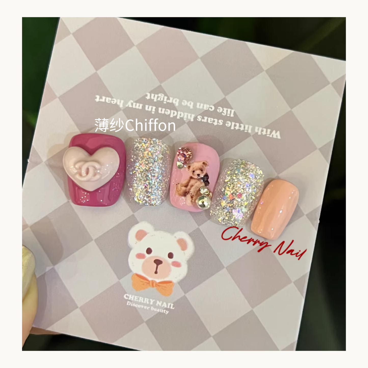 Cherry Nail Glitter Ethereal Reverie Series chiffon pink glitter nail design featuring soft pink gel, holographic glitter nails, teddy bear charm nail art, and 3D heart embellishment
