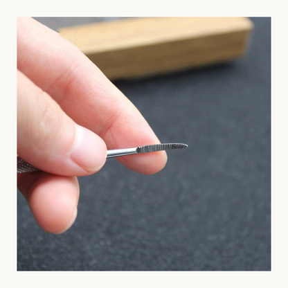 Hand holding the curved nail file's narrow abrasive tip