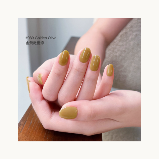 Golden olive green gel manicure in a warm indoor setting