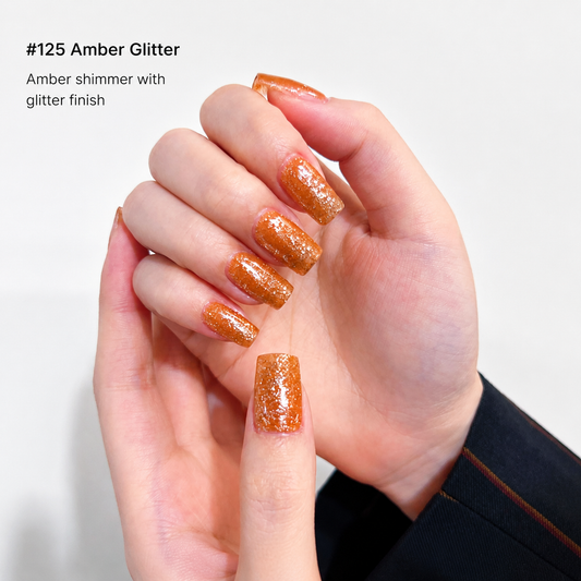 Warm amber-gold glitter nail color gel manicure on one hand