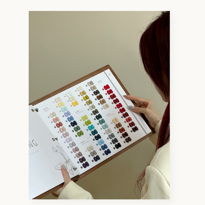 Hand flipping through the MODING 130-color swatch book showing complete color categories and shade layouts.