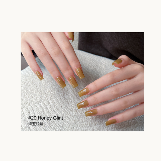 Honey-gold gel polish shown on glossy square nails over a textured towel