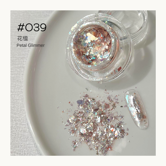 Rose-gold iridescent nail art flakes in a jar with a decorated nail swatch