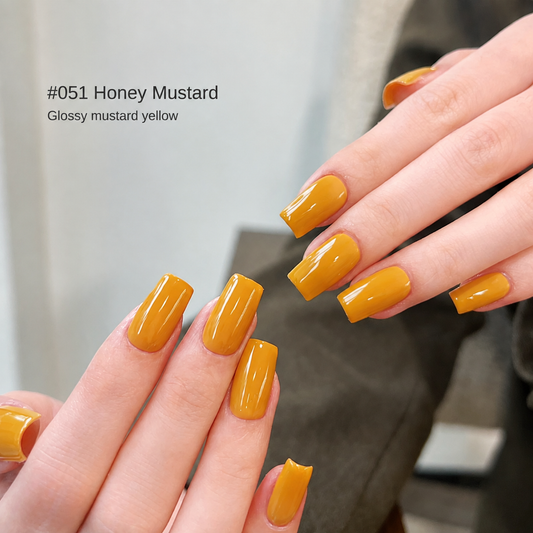 Glossy mustard yellow nail color gel manicure on two hands