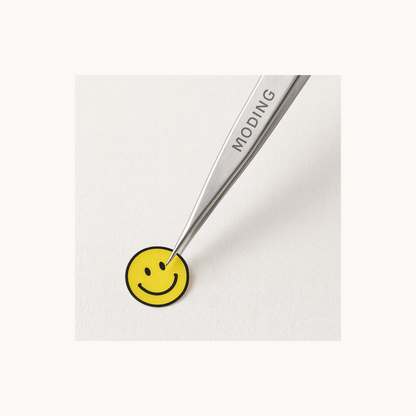 MODING TZ01 precision tweezers peeling a small smiley sticker for nail art application
