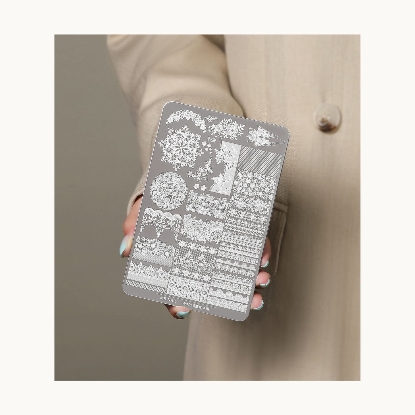 Hand holding MR NAIL W1008 lace stamping plate A version featuring intricate lace and floral nail art patterns for salon and DIY use