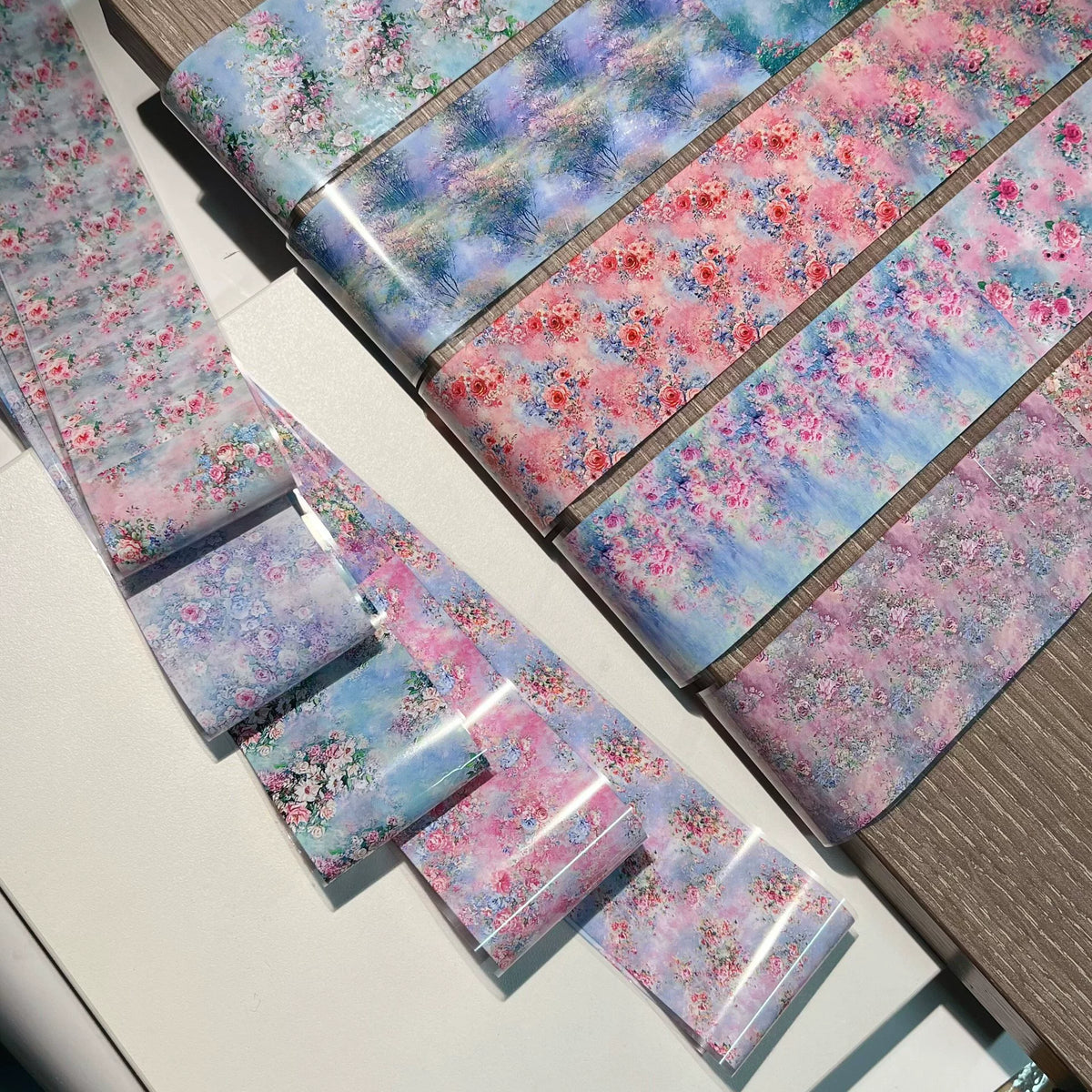 Close-up of floral and patchwork nail art transfer foil sheets