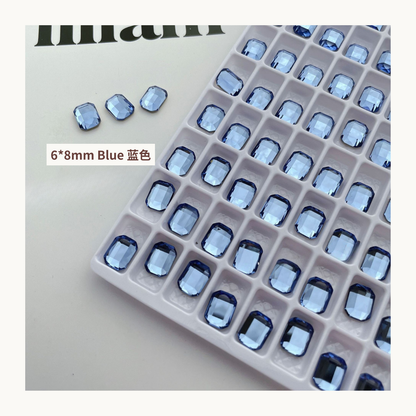 Clear octagon K9 flat back rhinestones blue 6x8mm shown on tray and single piece for nail art use