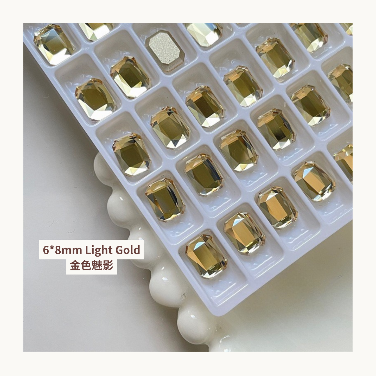 Clear octagon K9 flat back rhinestones light gold 6x8mm shown on tray and single piece for nail art use