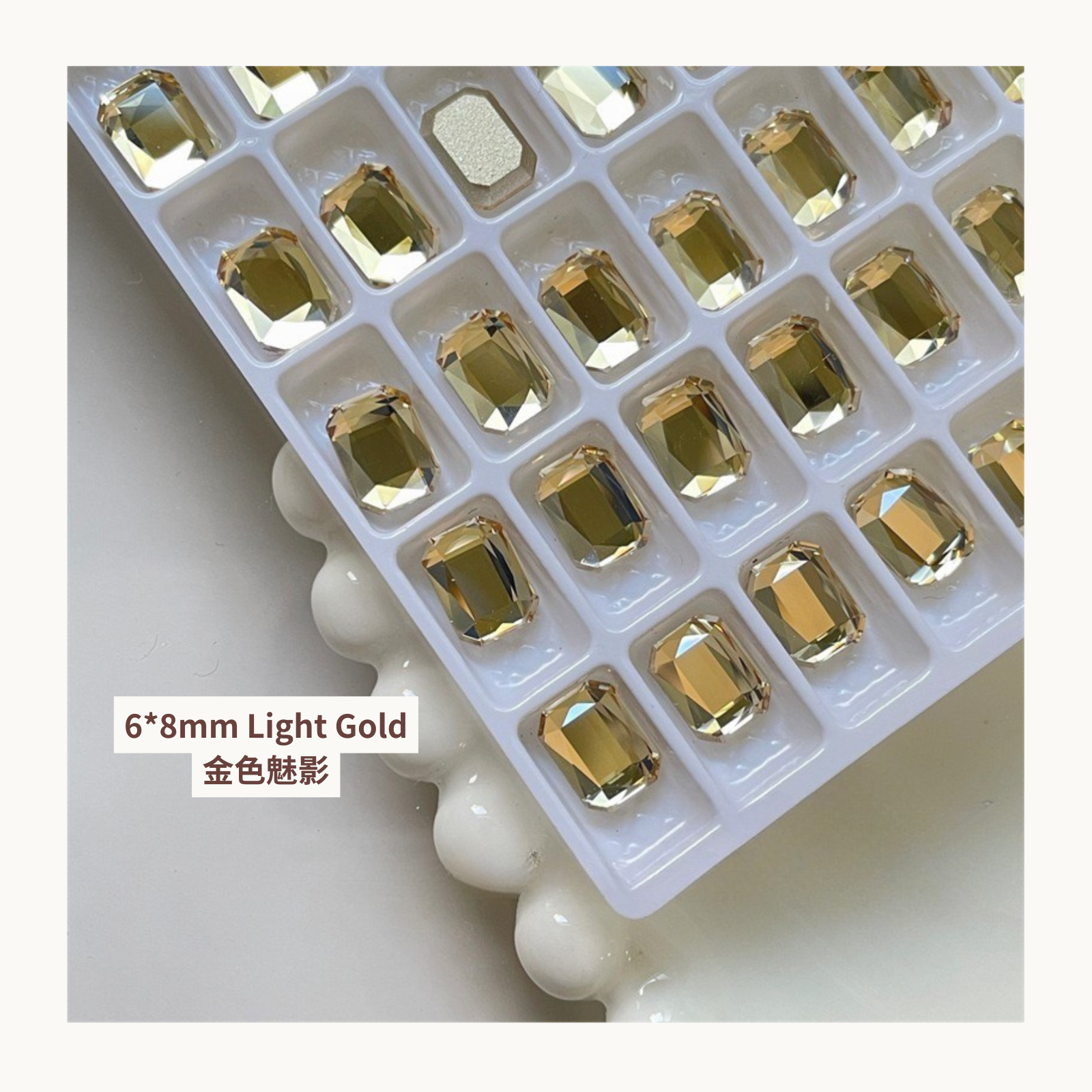 Clear octagon K9 flat back rhinestones light gold 6x8mm shown on tray and single piece for nail art use