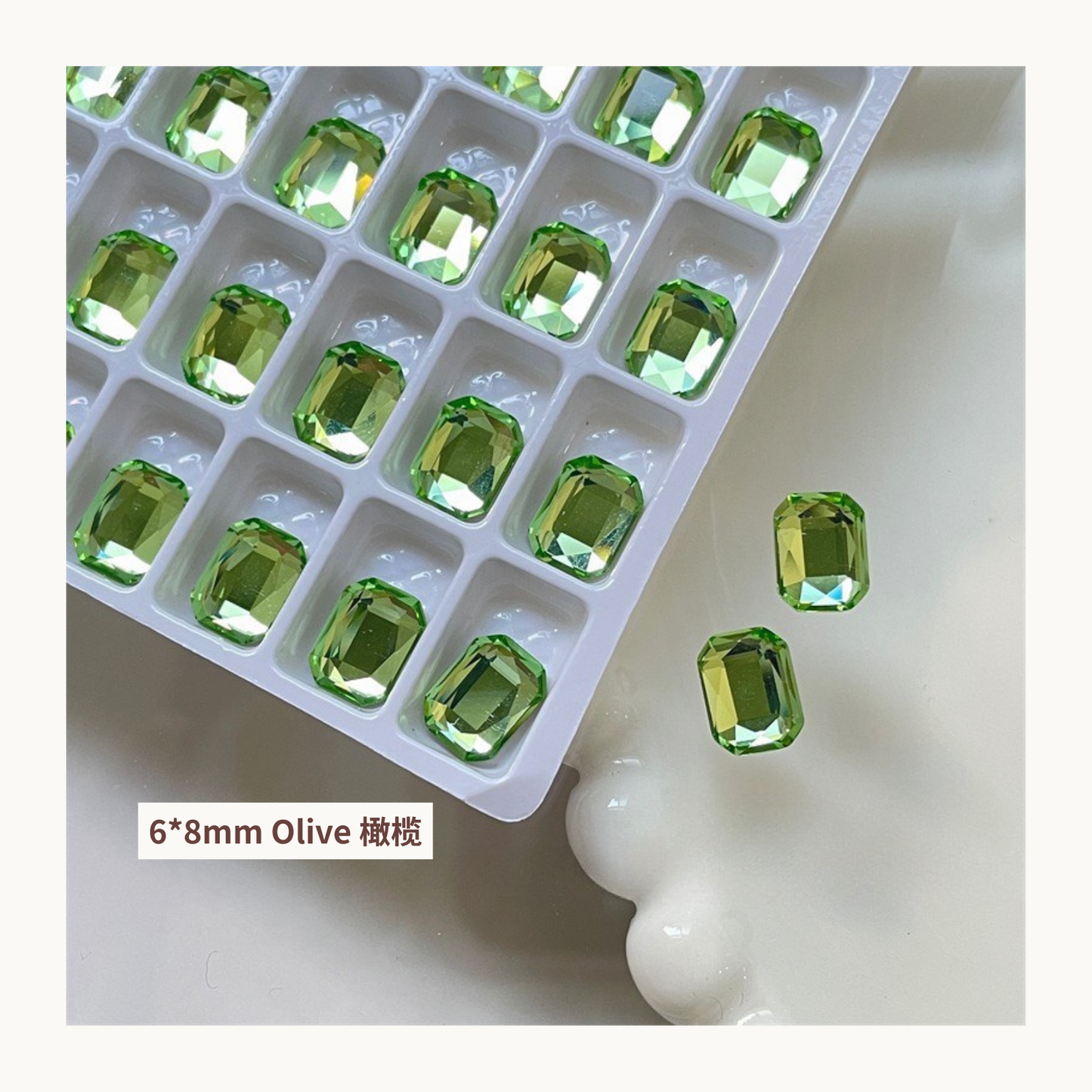 Clear octagon K9 flat back rhinestones olive 6x8mm shown on tray and single piece for nail art use