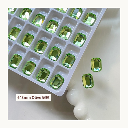 Clear octagon K9 flat back rhinestones olive 6x8mm shown on tray and single piece for nail art use