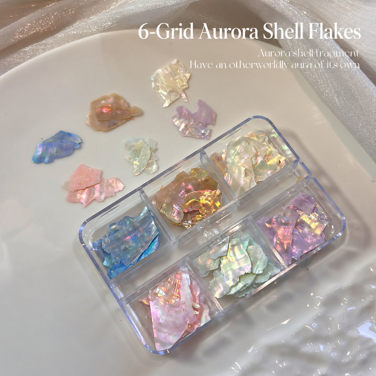 NF x Aurora Shell Nail Art Flakes in a clear six-grid box, with pastel iridescent pieces and loose colour samples on a plate.