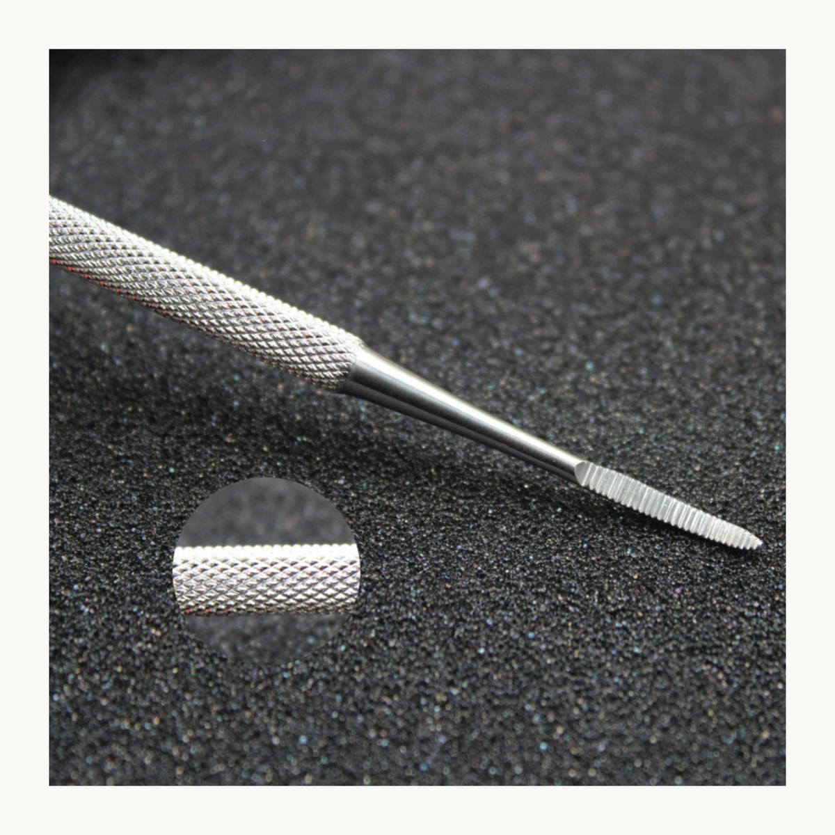 Close-up of curved nail file showing textured handle and abrasive end