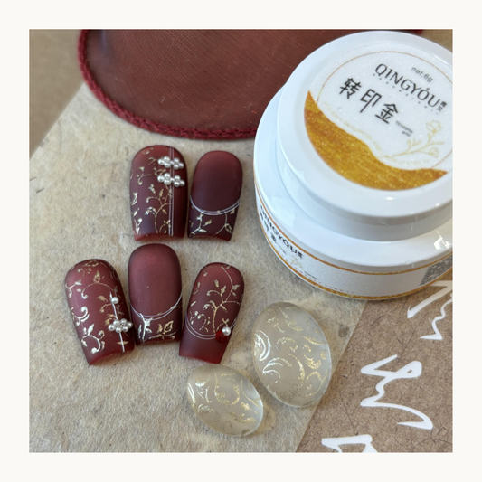 Gold transfer gel stamped floral nail art on burgundy matte nails using QingYou gold transfer paste.