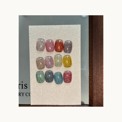 Full set of nail tips with rainbow diamond glitter effect in multiple colors.