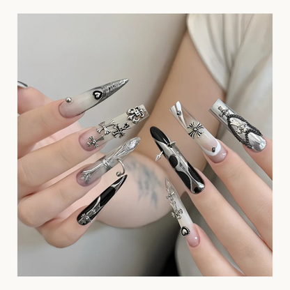 Silver gothic cross nail charms displayed on long decorated nails
