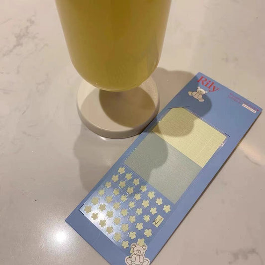 Blue nail sticker card with yellow flowers and panels beside a yellow glass