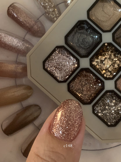 Close-up of rose-gold glitter gel on two fingernails beside the palette