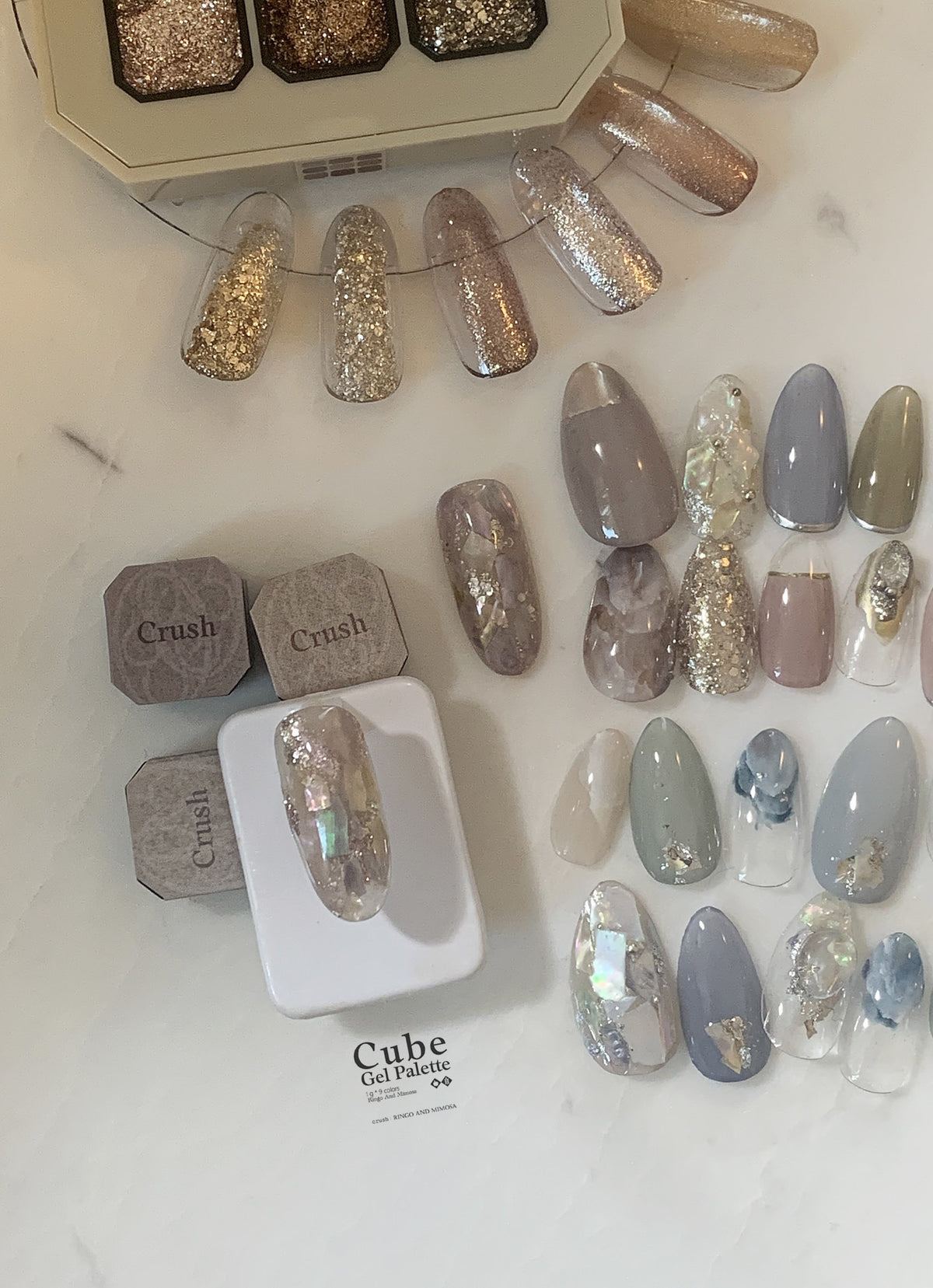 Gel palette display with neutral, blue-gray, and iridescent nail tips