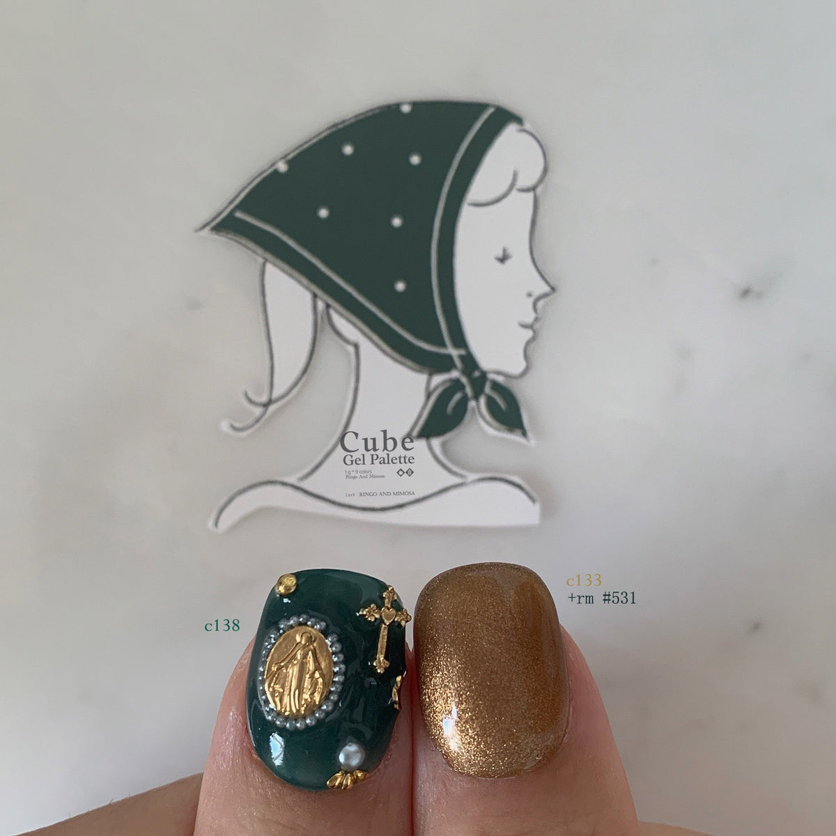 Close-up of deep teal and gold-brown soft gel manicure
