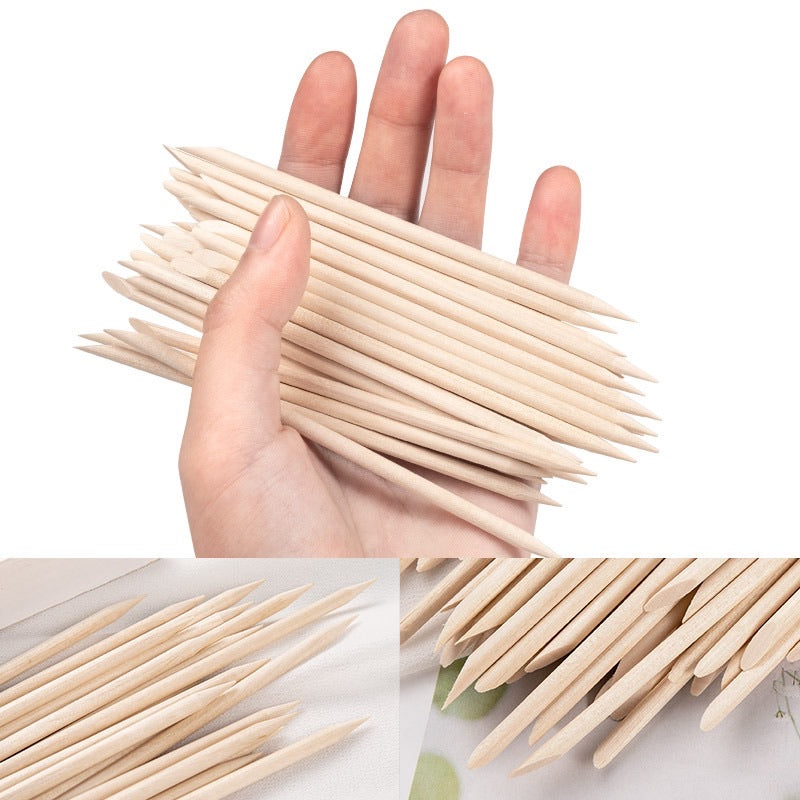 Hand holding pointed wooden nail art sticks with close-up detail insets