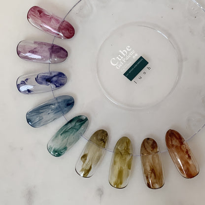 Translucent marbled soft gel swatches arranged on a clear display ring