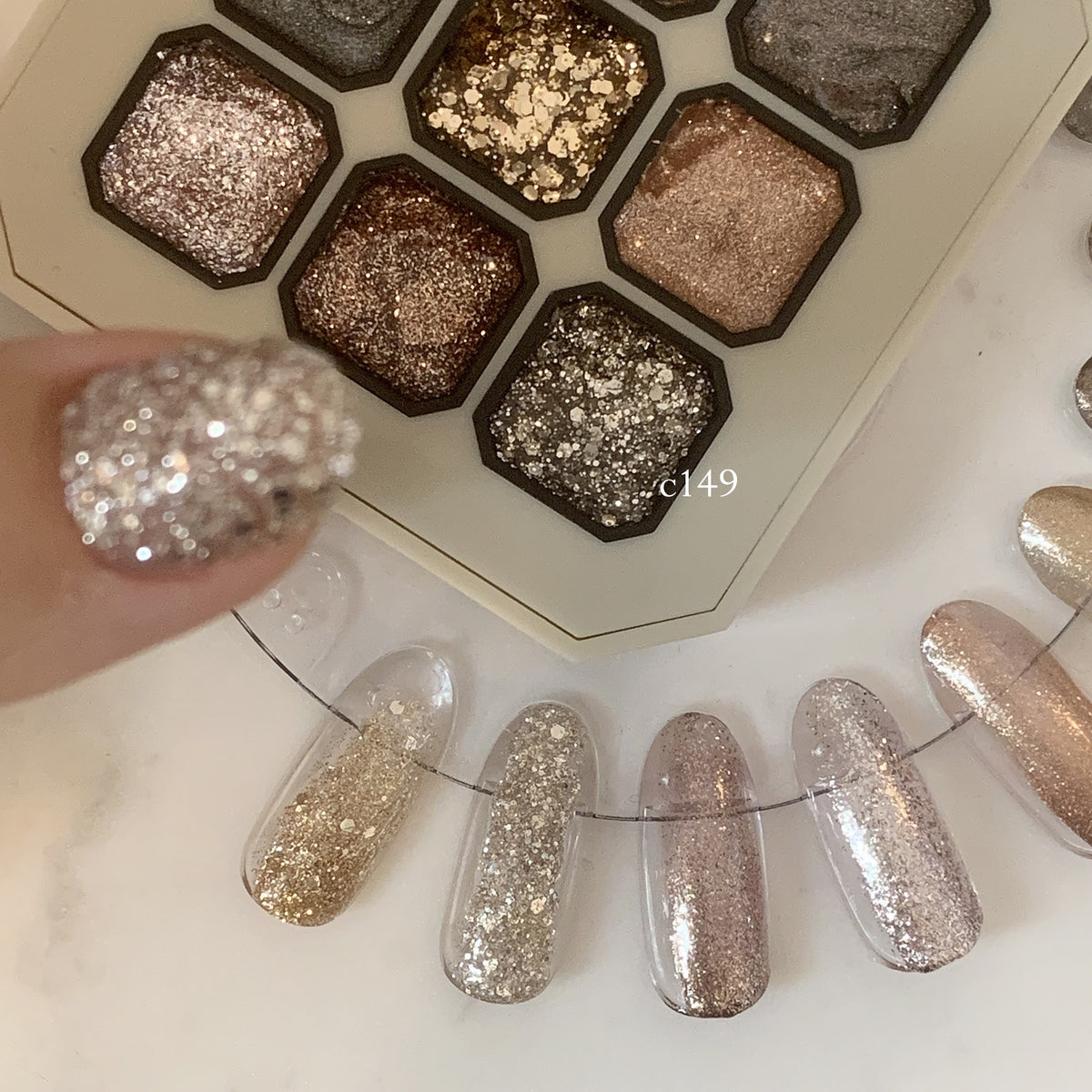 Close-up of silver glitter gel with reflective flakes beside the palette