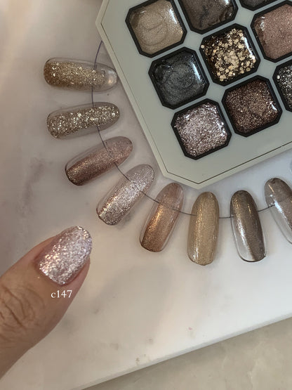 Close-up of silver glitter gel on a fingernail beside the palette