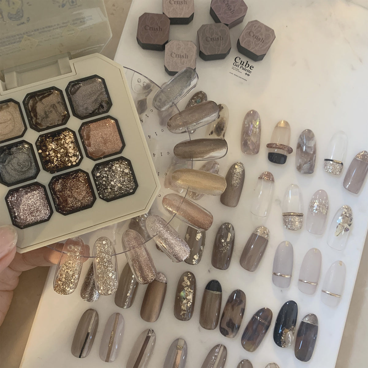 Nine-shade gel nail color palette with neutral metallic nail swatches