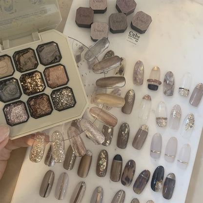 Nine-shade gel nail color palette with neutral metallic nail swatches