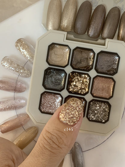 Close-up of chunky gold glitter gel on a fingernail over the palette