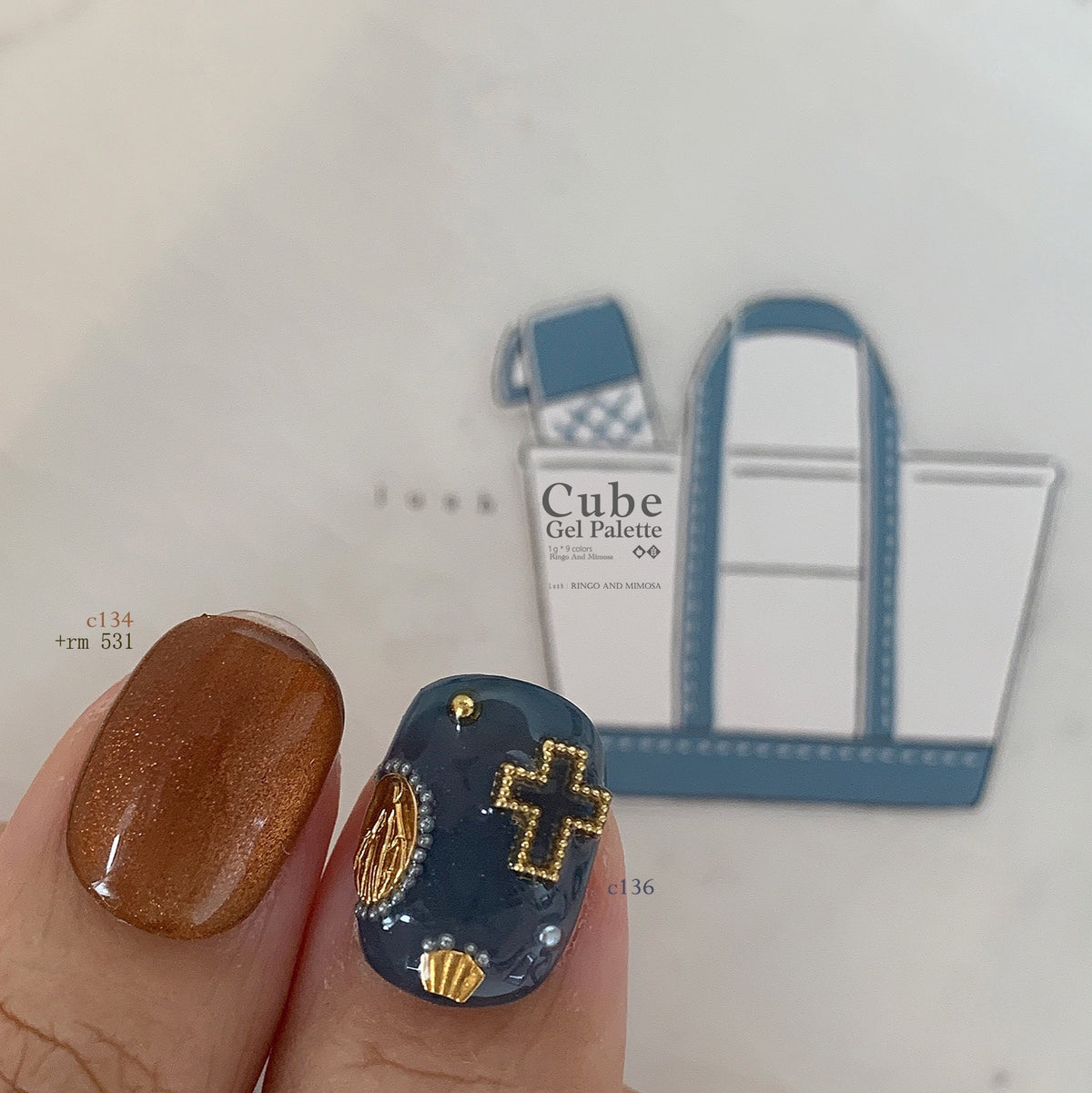 Close-up of orange-brown and navy soft gel manicure with gold accents