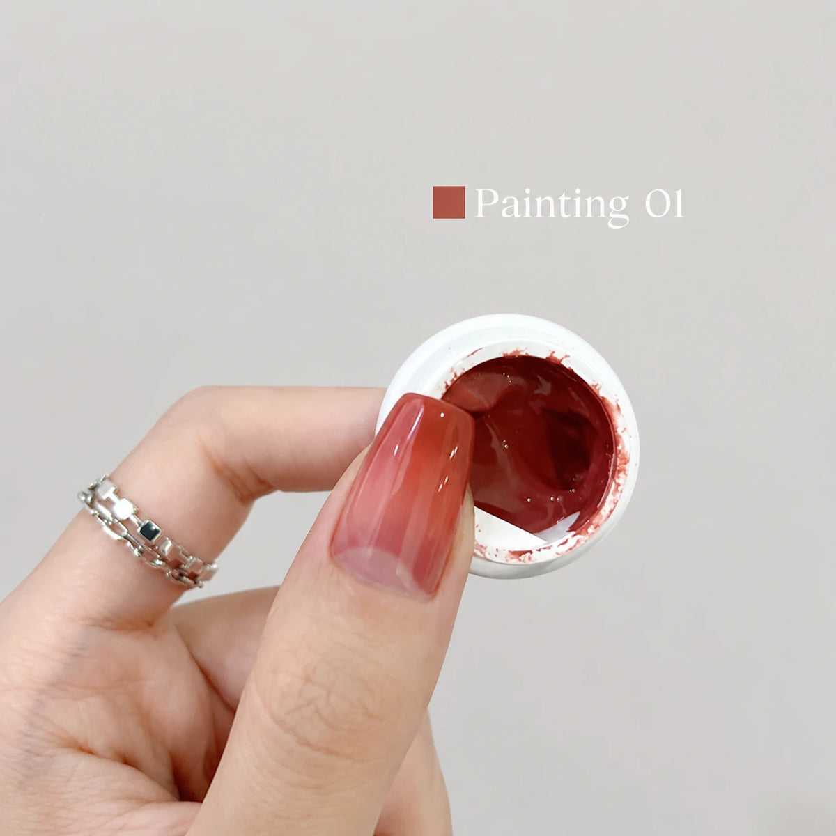YHH Patting Painting Chrome-Rubbable Pot Gel 5g, shade P01 – deep reddish-brown gel in an open pot beside a painted nail.