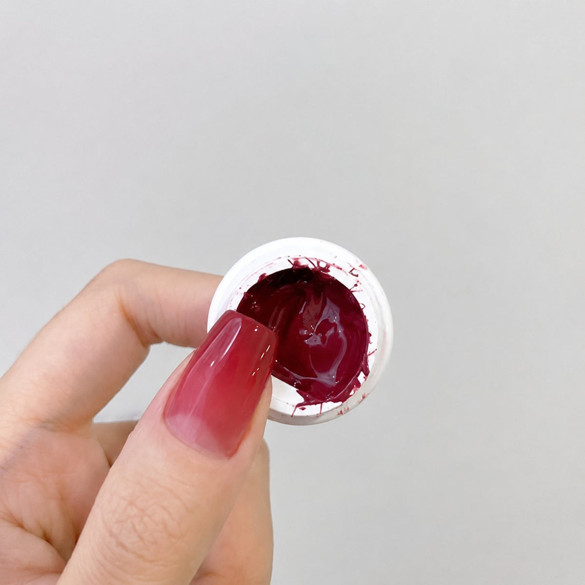 YHH Patting Painting Chrome-Rubbable Pot Gel 5g, shade P05 – deep wine-red gel in an open pot beside a painted nail.