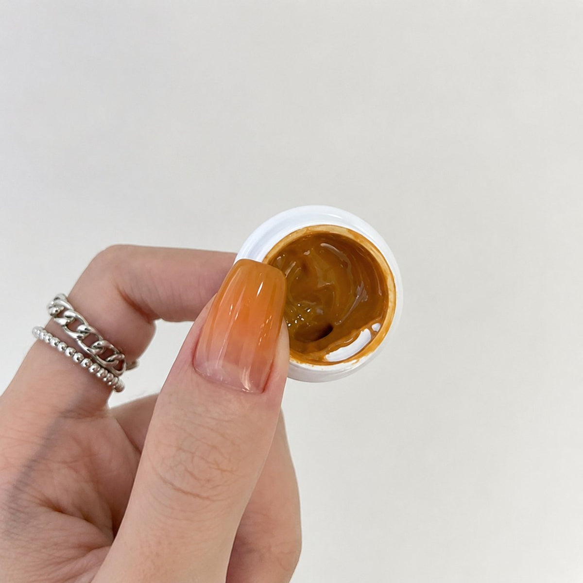 YHH Patting Painting Chrome-Rubbable Pot Gel 5g, shade P15 – amber-gold gel in an open pot beside a painted nail.